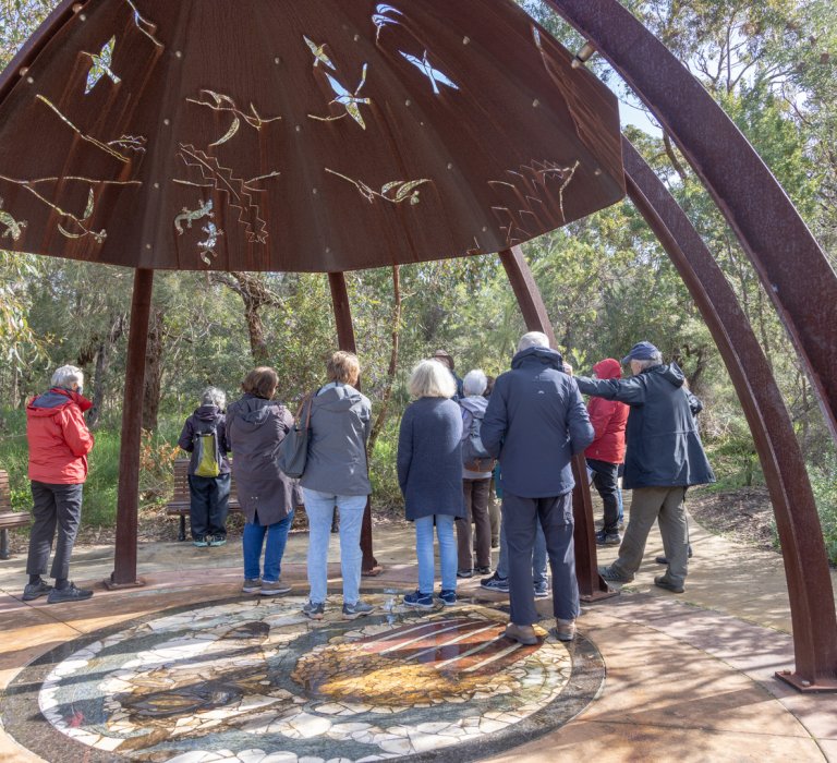 A volunteer guide speaks to a group of park visitors at Kings Park