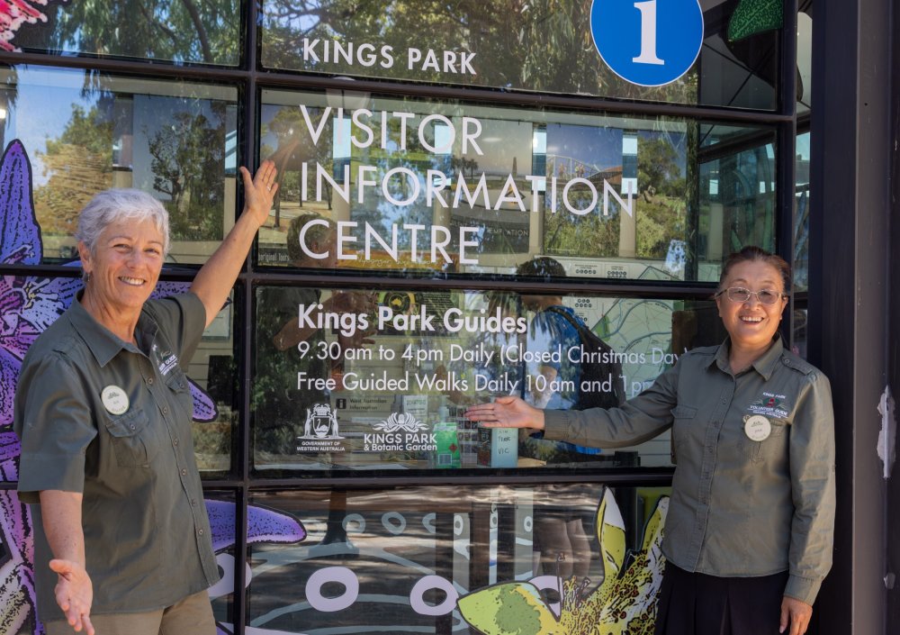 VIC employees smiling and pointing at the VIC entrance