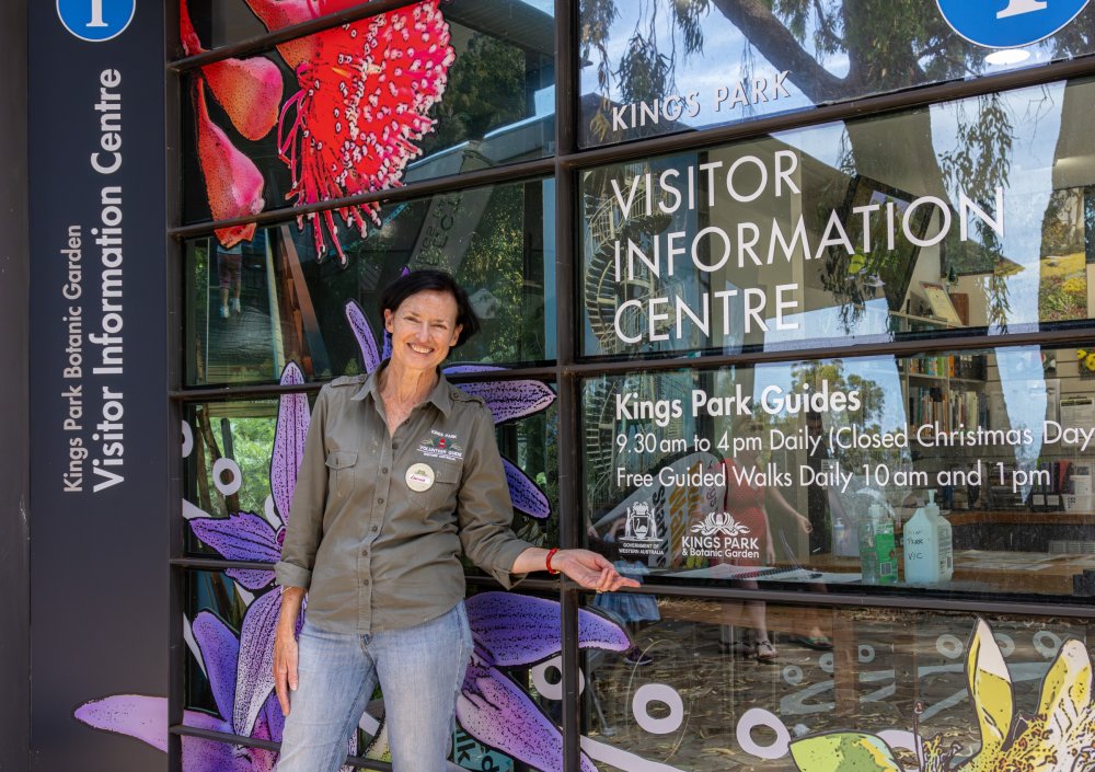 Edwina smiling and pointing at the VIC entrance sign