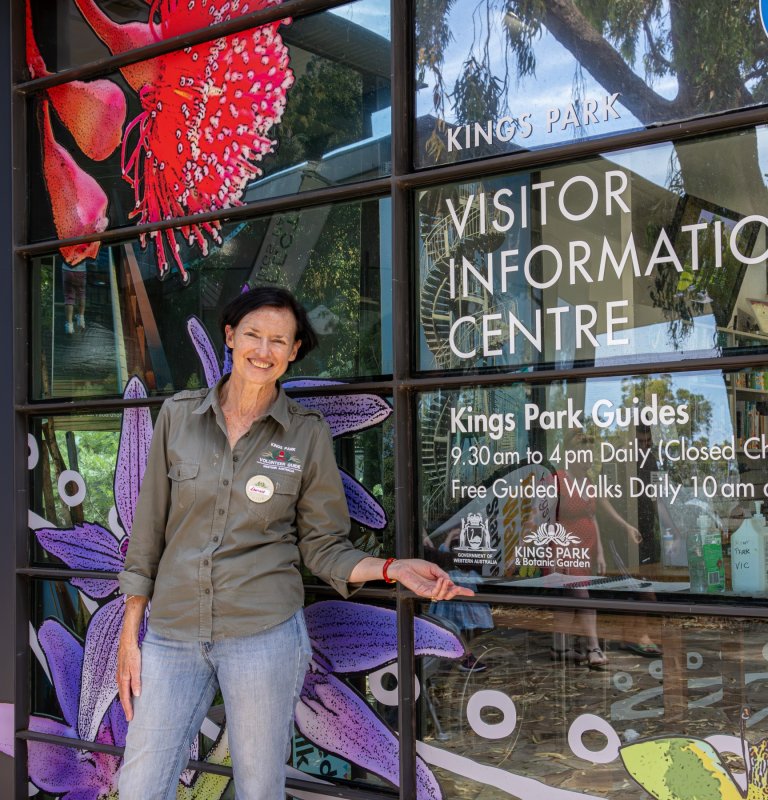 Edwina smiling and pointing at the VIC entrance sign