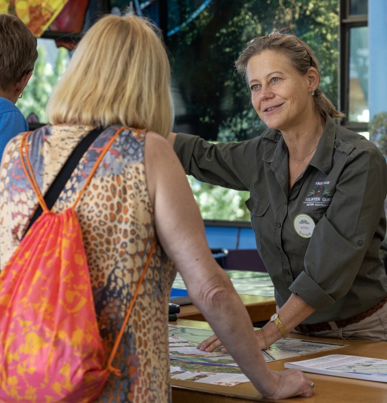 A friendly Kings Park Volunteer Guide directs a member of the public.